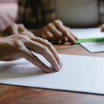 shallow focus photo of person using braille